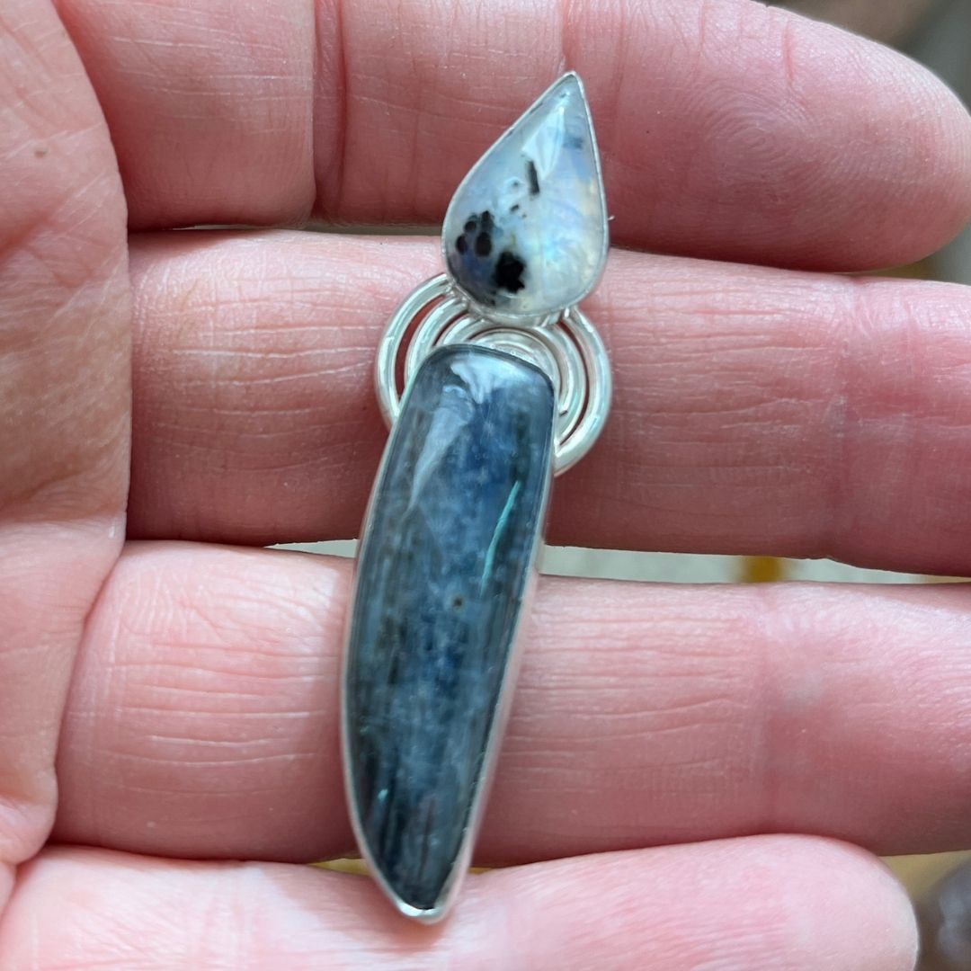 Colgante Arianrhod de plata de ley 925 con cianita azul y piedra luna engastadas, espiral grabada símbolo de la rueda del tiempo